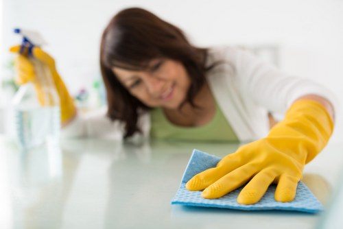 Person treating a wine stain on a dining table cloth using salt and blotting